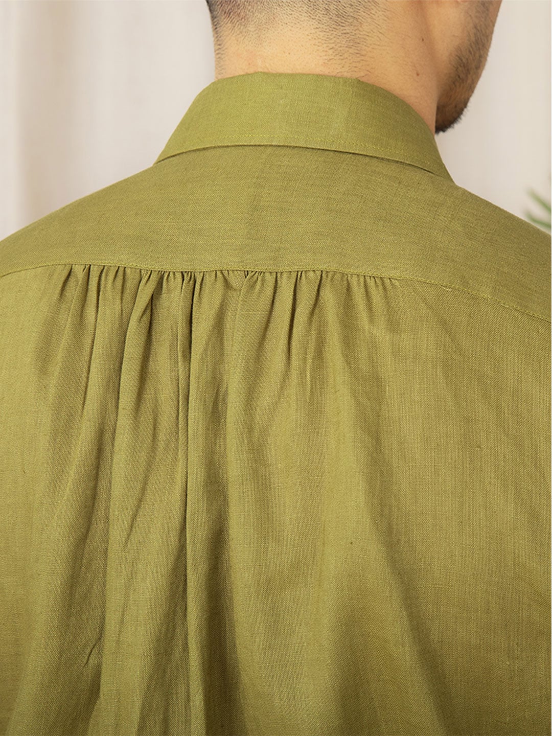 Close detail of linen trousers and white linen shirt