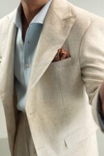Close-up of men's natural beige linen blazer with peak lapel and pocket square