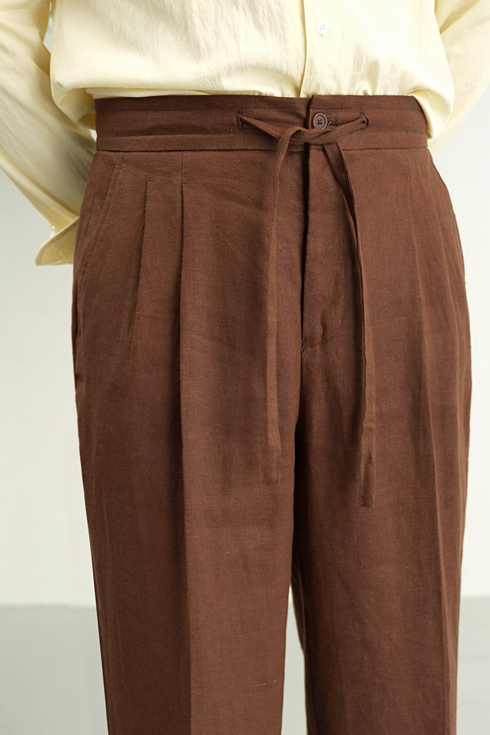 Close-up of linen drawstring waistband and front pleats