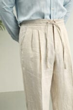 Natural linen high-rise trousers styled with a white shirt and loafers